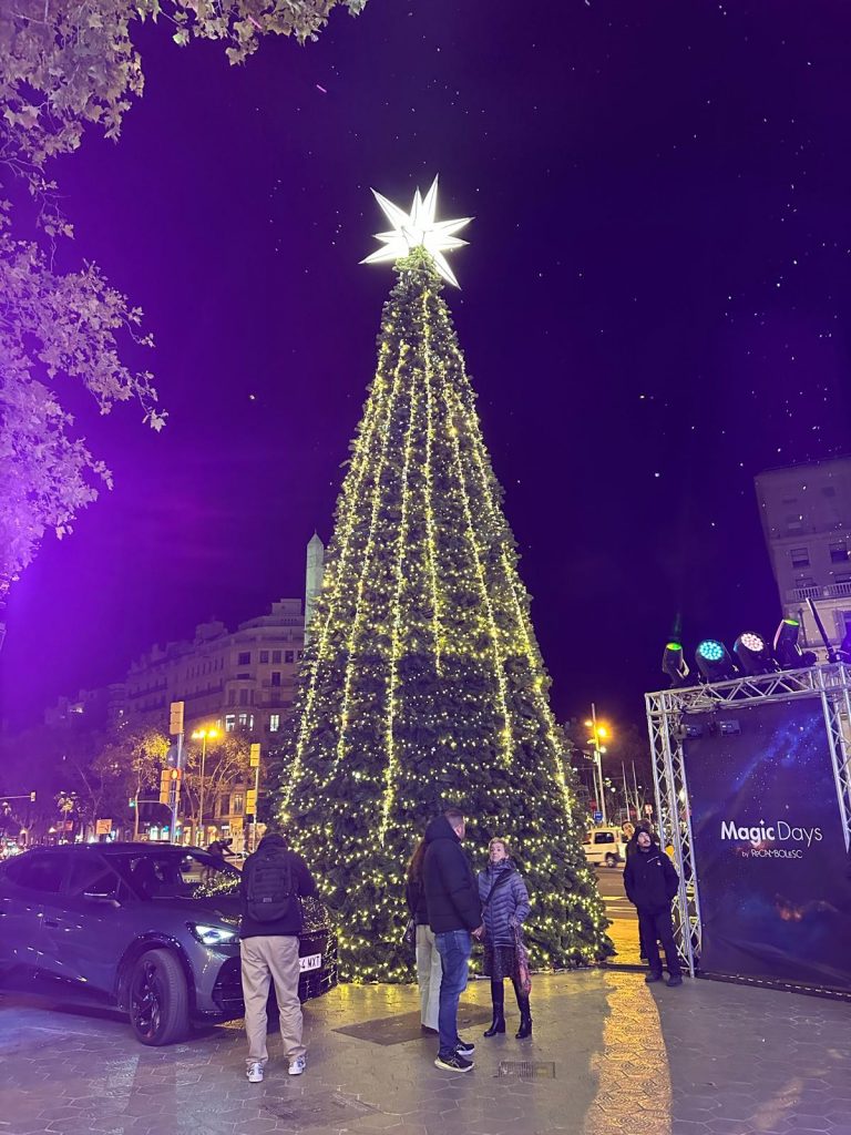 Árbol navideño iluminado en Passeig de Gràcia, coronado por la estrella de Gaudí.