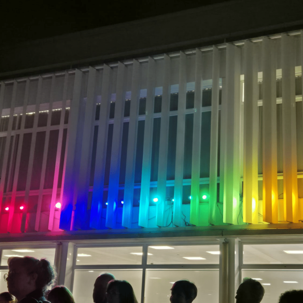 Fachada iluminada con focos LED de colores en una instalación del CICAT durante Encén Montilivi 2025
